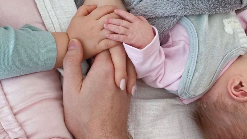 Bibi, Julian und Lio Claßens Hände und ihre neugeborene Tochter Emily, März 2020